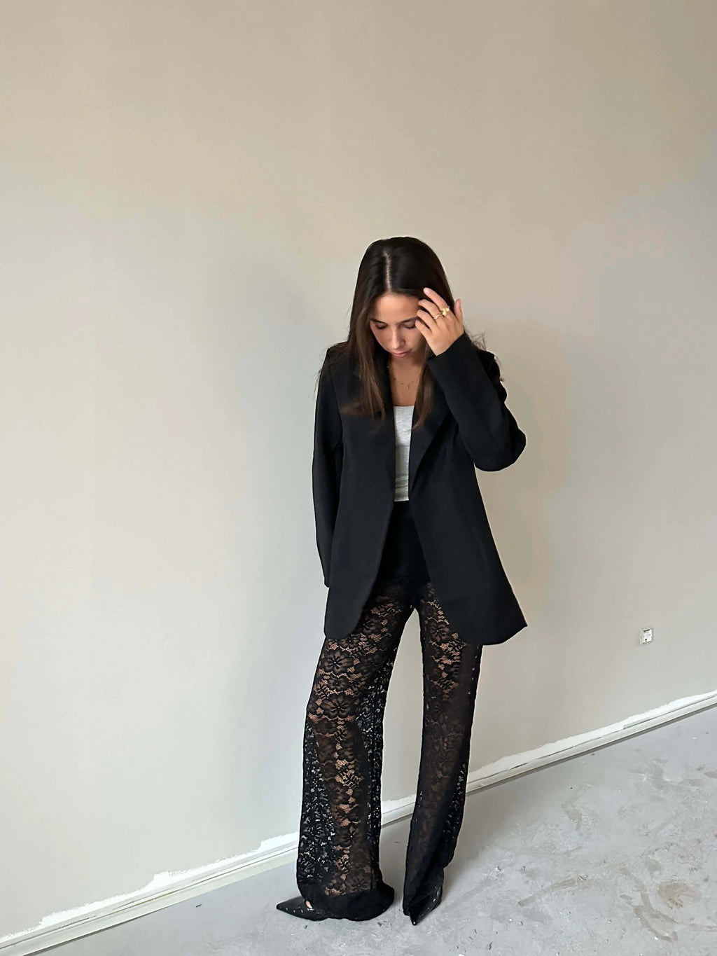 Woman wearing Valentina™ Luxe Kanten Broek with black blazer standing against a minimalist background.