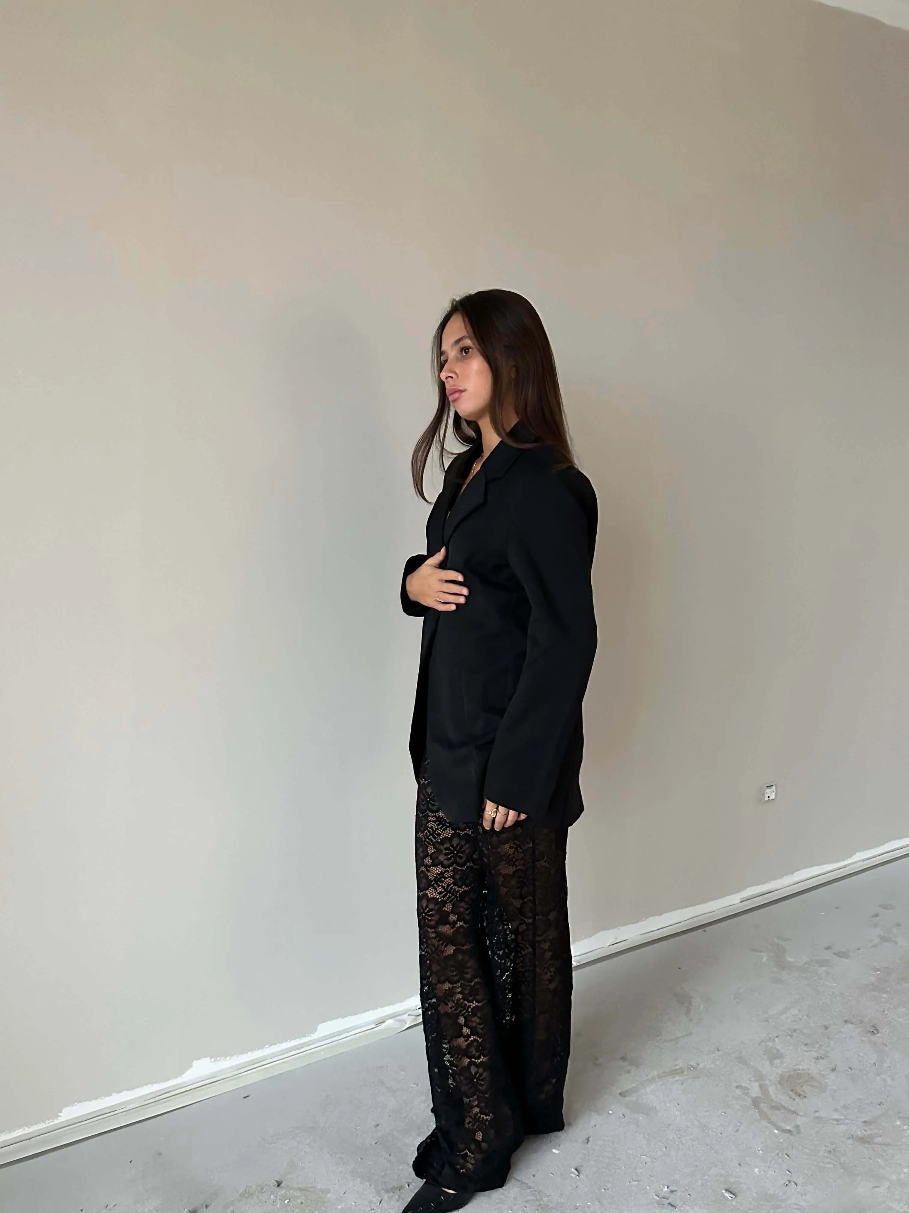 Woman wearing Valentina™ Luxe Kanten Broek with elegant lace details and a black blazer, showcasing a stylish and chic look.