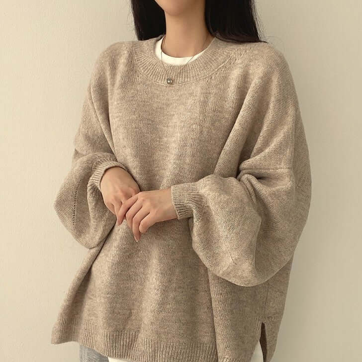 Woman wearing beige loose fit sweater with lantern sleeves for a chic, casual look